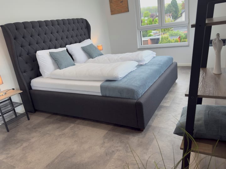 Chumba cha kulala cha kisasa chenye muunganisho wa moja kwa moja na sebule chenye mandhari nzuri.