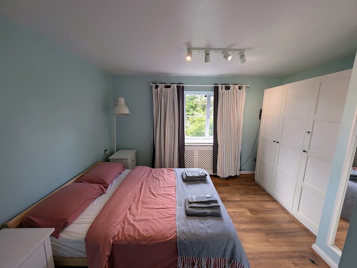 Este luminoso y acogedor dormitorio en suite ofrece un montón de espacio de almacenamiento y perchas para secar la ropa. Una mezcla perfecta de comodidad y practicidad para tu estancia.