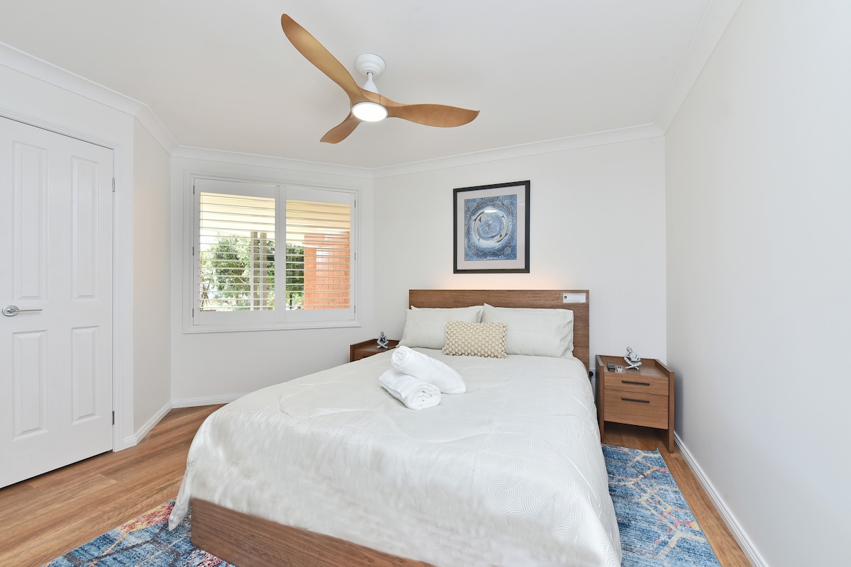 בחדר שינה 2 יש מיטת קווין סייז ומנורת לילה בתוך ראש המיטה.