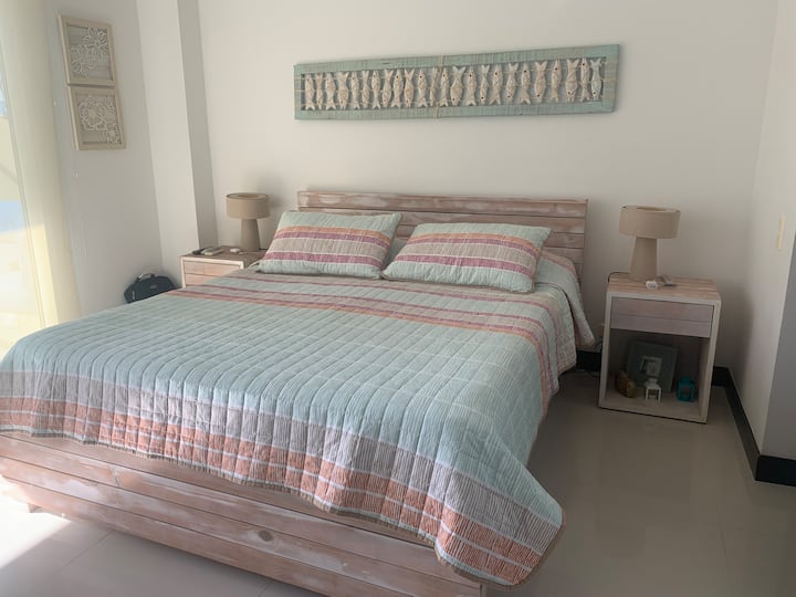 Cama doble con dos mesas de noche y tv