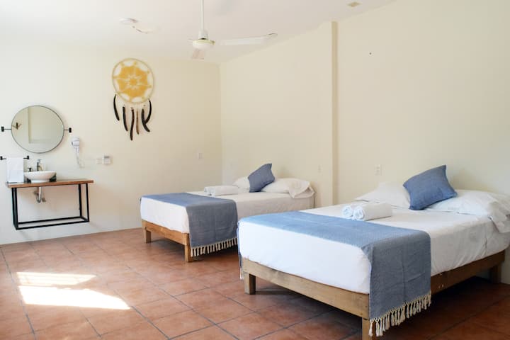 舒适的房间，配备两张双人床、空调、吊扇、熨斗、洗手液、吹风机和镜子。 隔壁的全功能卫生间配备洗发水和沐浴露。 