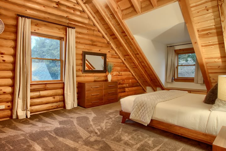 Inviting bedroom with rustic wooden walls and a soft bed.