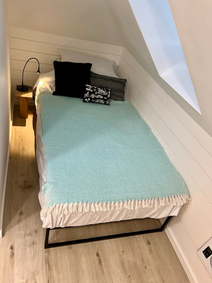 Ორადგილიანი საწოლი სხვენში, ღია ფანჯრით. 