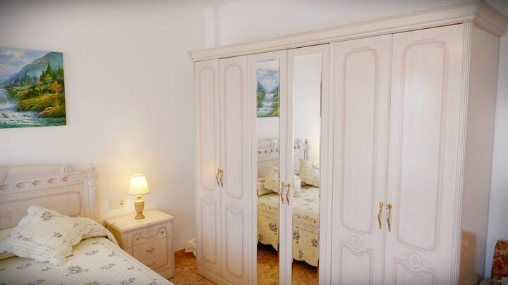 Chambre avec lit double et salle de bains suite.