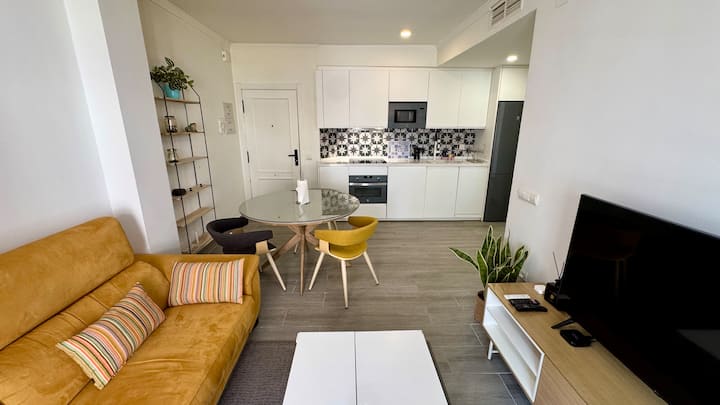 Salón con televisión y acceso a la cocina