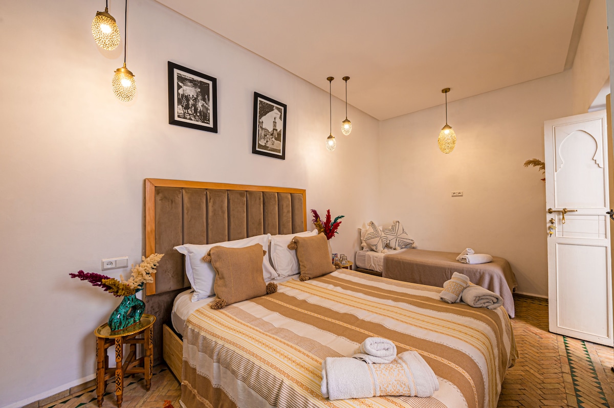Vue d'ensemble des deux lits élégants dans la chambre triple premium