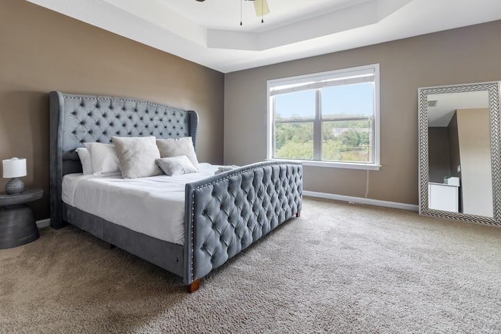 Relájate en el dormitorio principal con una lujosa cama tamaño king y un suave suelo alfombrado: tu refugio perfecto para noches de descanso.