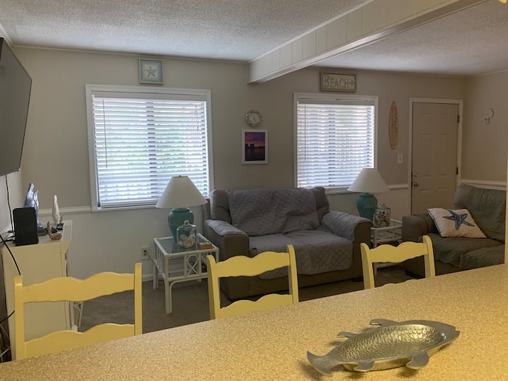 Sala de estar abierta y cocina con TV de pantalla grande