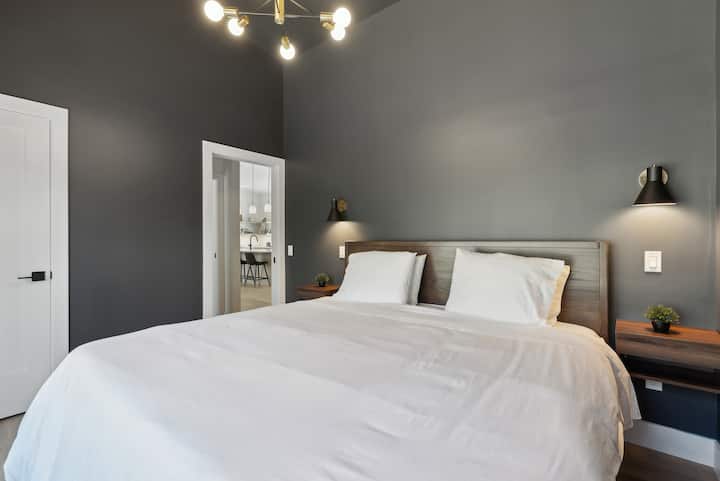 Tmavé, náladové a pripravené na hlboký spánok.

Táto spálňa s manželskou posteľou King spája čierne steny s teplými orechovými prvkami a veľkými oknami, ktoré rámujú dramatickú skalnú rímsu — útulnú, tichú a bez námahy chladnú.