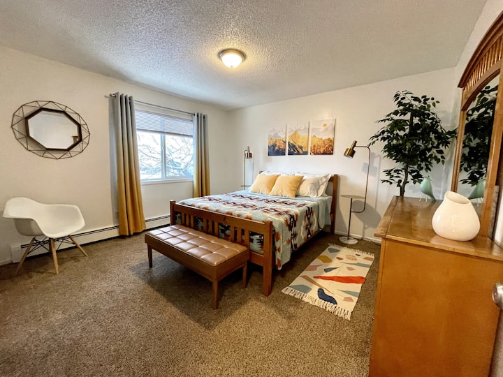 安静舒适的主卧室，配备酒店式床上用品和柔和的照明。