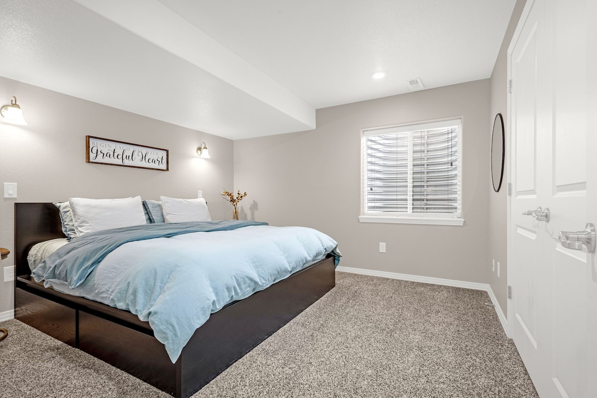 Bright basement bedroom with King bed. It has a bathroom (with shower) in the hall that is shared with the basement Queen bedroom and the office with pull-down bed.