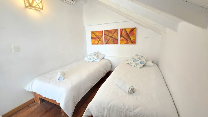 El cuarto dos es pequeno, esta ubicado en el  segundo piso en el mezanine de madera, techo diagonal, por ser el ultimo piso del edifiicio;   las camas son sencillas; tienen rodachines por si las quieren unir. el cuarto cuenta con aire acondicionado