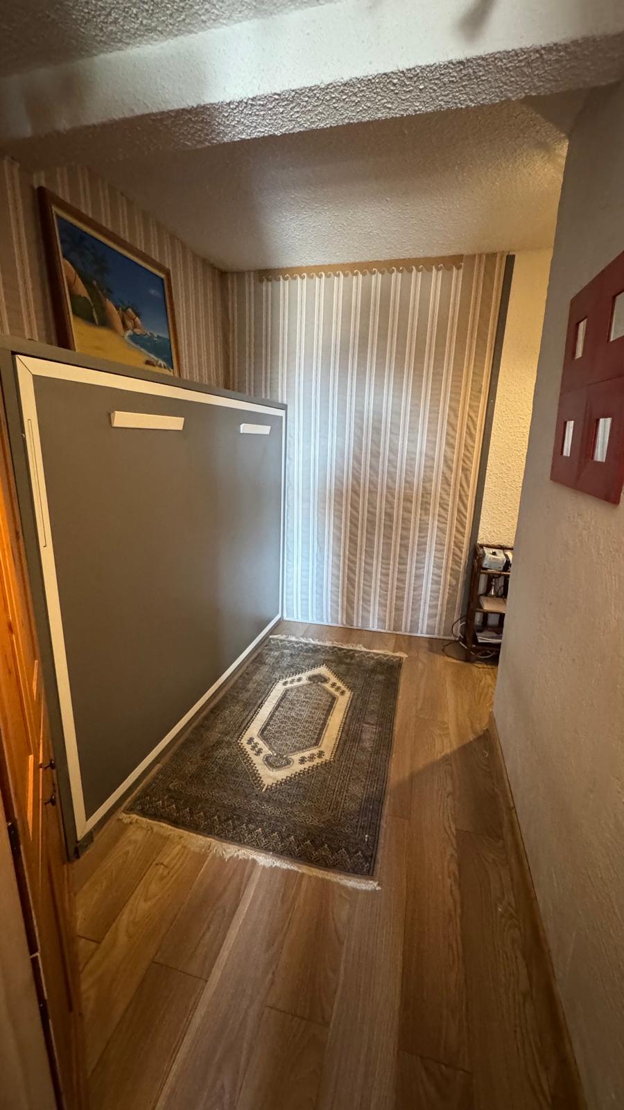 Zona de noche con cama plegable
Cama de pared práctica en un espacio cálido y bien organizado.