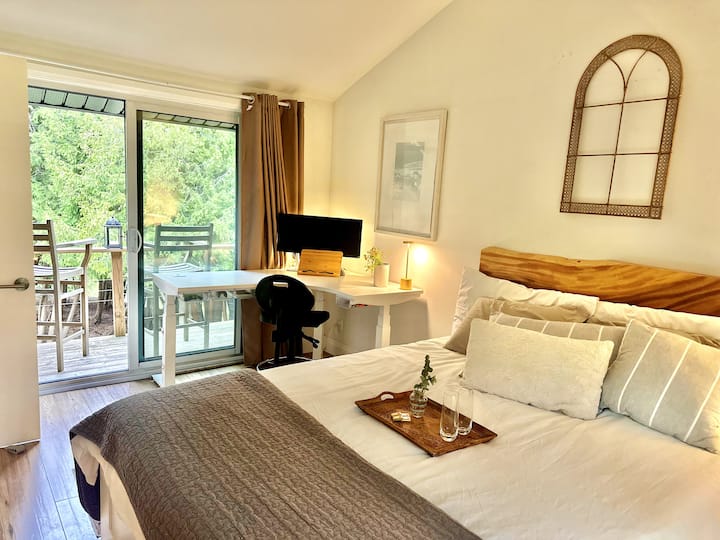 Bureau, lit Queen Size, balcon privé avec vue sur la rivière, les prairies et la forêt.