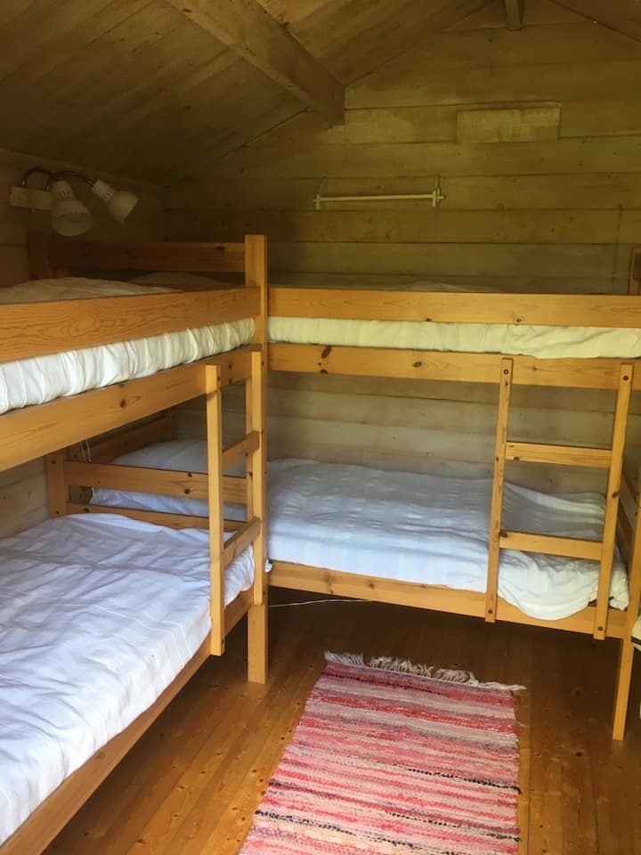 Ჩვენს ფარდულში, რომელსაც სკალმანს ვეძახით, გვაქვს ორი ორსართულიანი საწოლი, სულ 4 ადამიანს შეუძლია აქ დაძინება. Იქნებ ოჯახი, რომელსაც ორი შვილი ჰყავს? Ასევე, ხელმისაწვდომია კომოდი და ქურთუკის საკიდები.