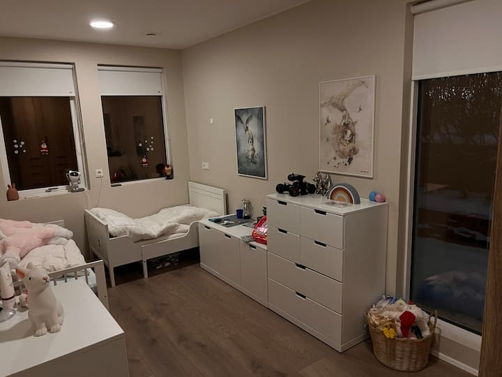 Detská izba s dvoma detskými postieľkami a hračkami.