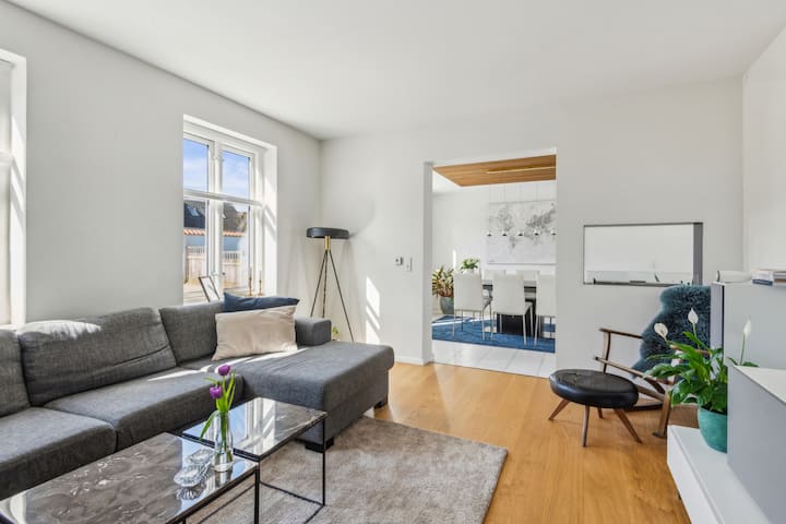 De woonkamer op de begane grond heeft een grote 65" tv en een open biohaard in de muur tussen de woonkamer en keuken-eetkamer.