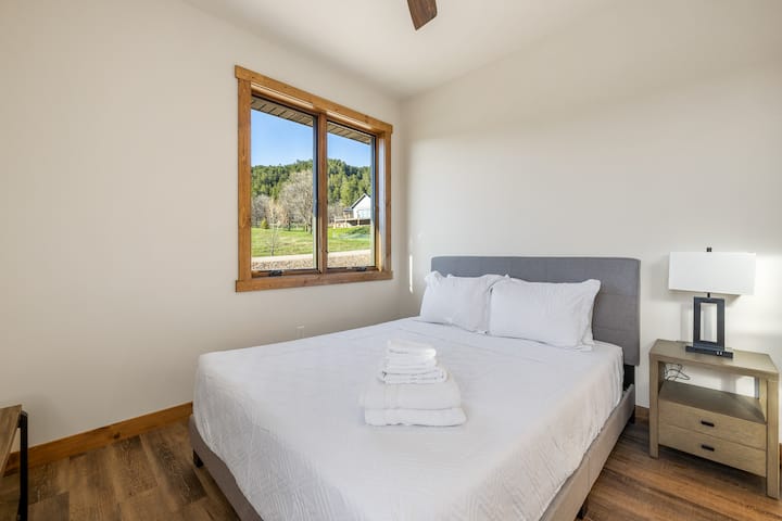 Una mesita de noche está convenientemente ubicada al lado de la cama, perfecta para tus elementos esenciales