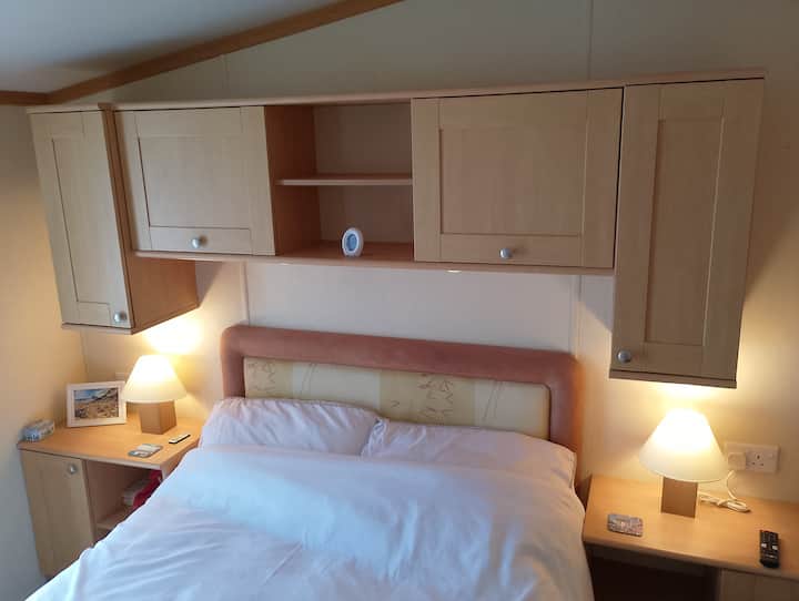 Dormitorio doble con mucho espacio de almacenamiento, cómoda con espejo.