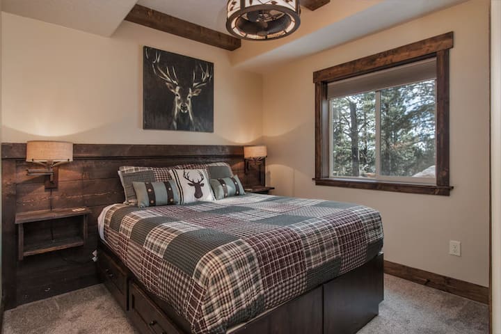 Acogedor dormitorio con una cama tamaño queen, detalles rústicos en madera y una gran ventana con vistas tranquilas al bosque. Espacio cómodo para parejas o viajeros solitarios.