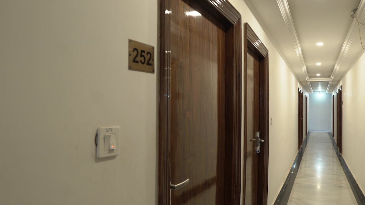 The hallway presents a clean and well-lit environment, with polished marble flooring. Two wooden doors are visible, each with simple, elegant hardware. Room number 252 is clearly marked, contributing to a sense of organization and accessibility.