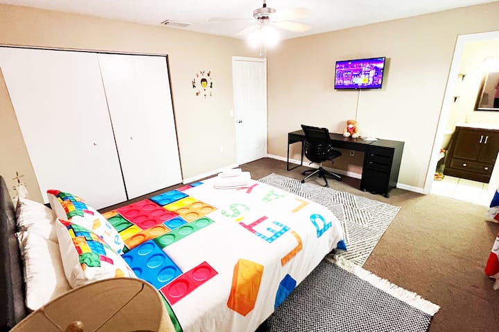 Dhomë gjumi kryesore me tavolinë pune dhe pamje nga kopshti e dekoruar me një temë Legoland.