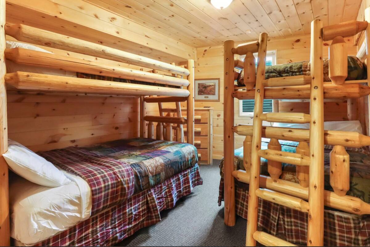 Lits superposés rustiques en rondins, courtepointes confortables et beaucoup d'espace pour tout le monde : cette chambre superposée de Northwoods est un favori pour les familles et les groupes! Une ambiance de soirée pyjama dans un chalet!