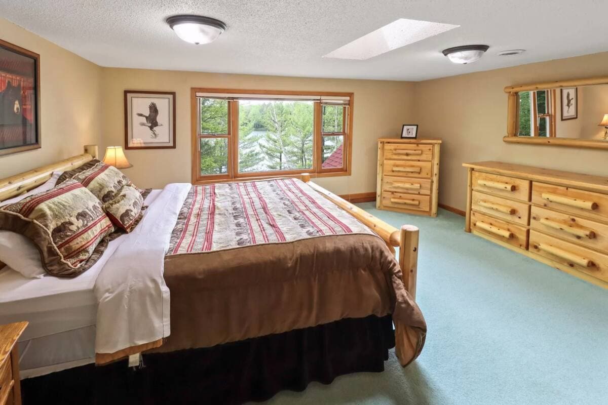 Réveillez-vous au murmure des pins et à la vue du lac par la fenêtre. Cette chambre principale spacieuse est l'endroit idéal pour se ressourcer après une journée d'aventure, ou simplement pour se détendre.