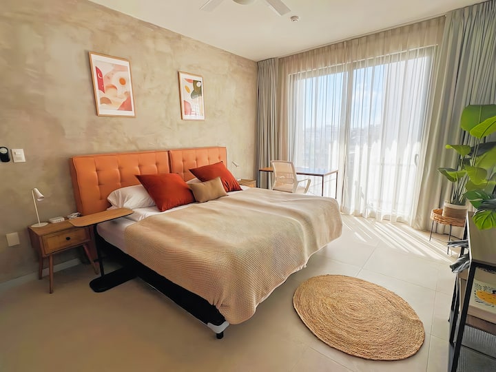 El dormitorio cuenta con una cama tamaño king súper cómoda y nueva, un televisor, un espejo y un escritorio. La habitación está equipada con cortinas opacas para una noche de sueño reparador y aire acondicionado para mantenerte cómodo.