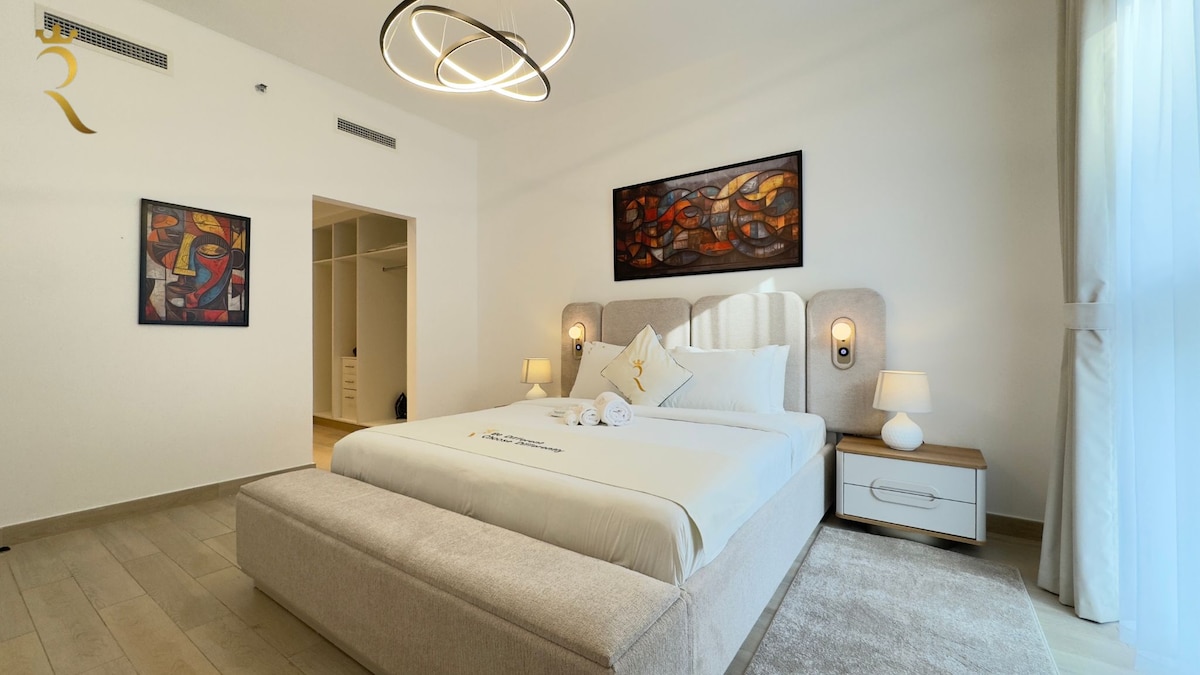 Ელეგანტური სასტუმრო ოთახი კედლის ფერადი ხელოვნებითა და კომფორტული საძილე სივრცით.