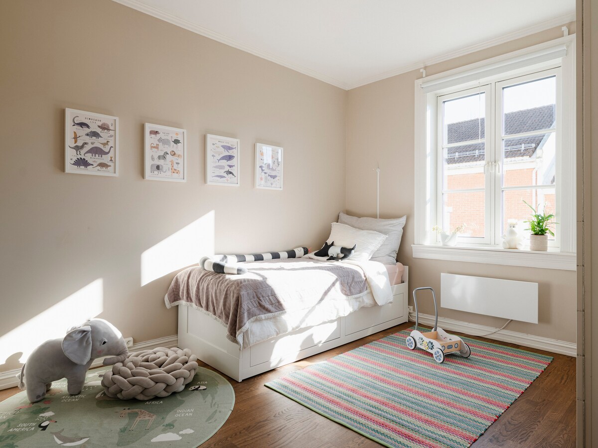 Ruim en zonnig – dit is de grootste slaapkamer, de hele dag door gevuld met natuurlijk licht. Het bed wordt op de foto als een eenpersoonsbed weergegeven, maar het is een uittrekbaar bed dat gemakkelijk kan worden omgebouwd tot een comfortabel tweepersoonsbed, afhankelijk van je behoeften.