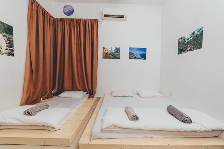 חדר שינה 2 כולל מיטת קווין סייז אחת ומזרן רצפה אחד, המציעים סידורי שינה נוחים לשלושה אורחים.