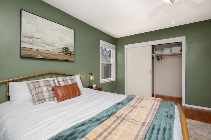 Lit queen confortable, rangement pour vêtements et espace de travail dédié aux télétravailleurs.