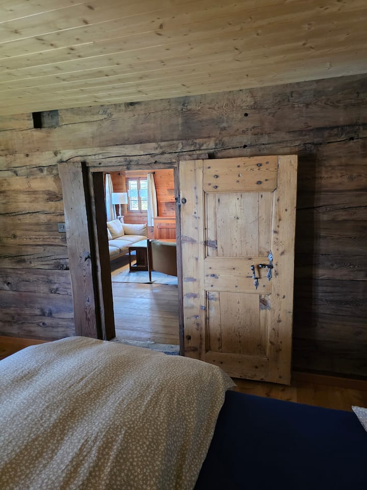 Брачен кревет (широк 150-179 см). Во собата има плакар и маса за работа. Бања и тоалет на подот. Во соседната дневна соба има дополнителен единечен кревет 90 x 200 