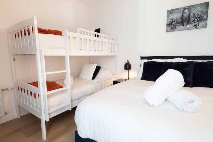 Chambre familiale à l’aménagement optimisé, avec un lit Queen Size pour les parents et un lit superposé pour les enfants.