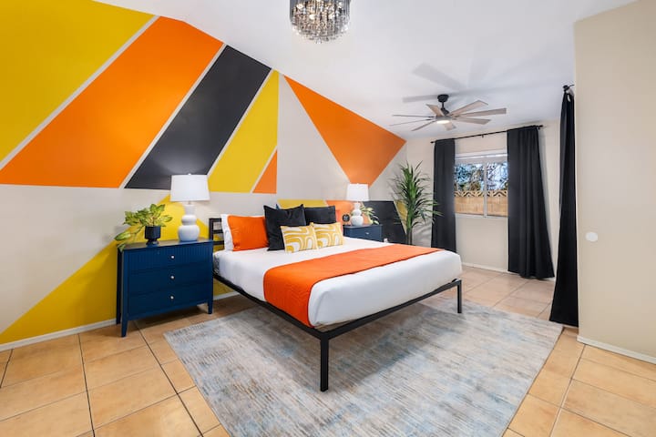 Опуштете се во голема, пространа спална соба со луксузен брачен кревет и смирувачки пустински тонови.