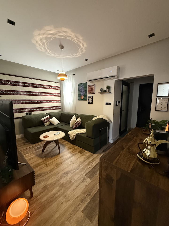 Dnevni boravak: elegantan zeleni kauč, topla rasvjeta i živopisna umjetnička djela stvaraju ugodnu atmosferu!