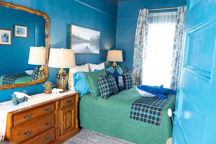 Manželská posteľ s komodou a skriňou na uloženie oblečenia.