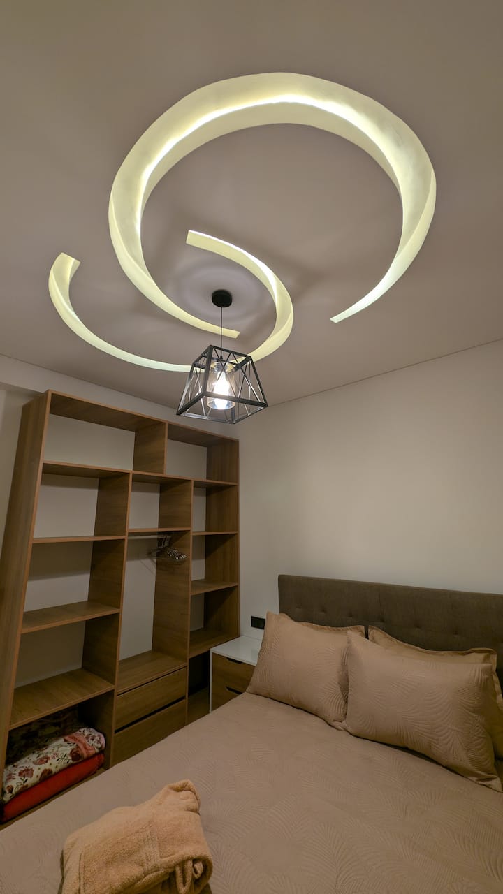 Opustite se u svijetloj i udobnoj spavaćoj sobi dizajniranoj za udobnost. Udoban krevet, meka posteljina, dovoljno prostora za pohranu i mirna atmosfera savršeno su utočište za odmor, punjenje baterija i uživanje u mirnom snu.