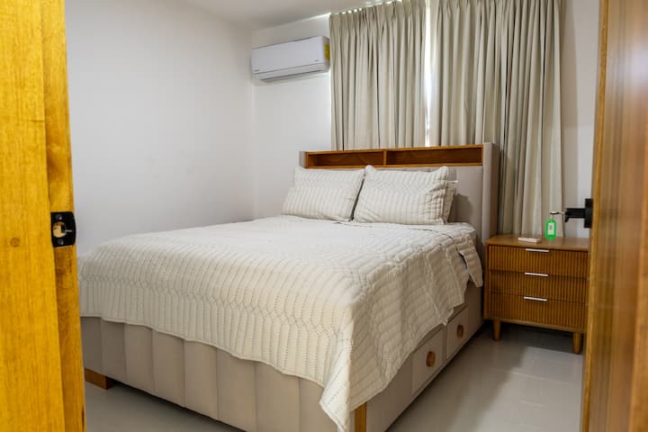 Habitación secundaria con cama queen, aire acondicionado y colchón de alta calidad para un descanso placentero