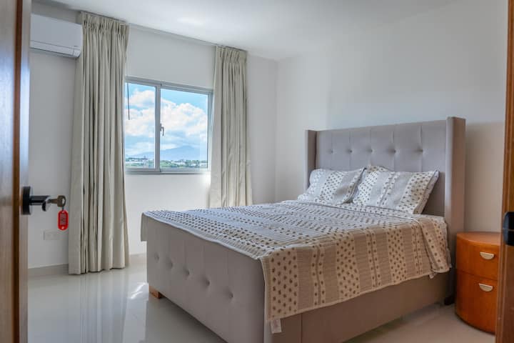 Habitación secundaria con cama queen, aire acondicionado y colchón de alta calidad para un descanso placentero