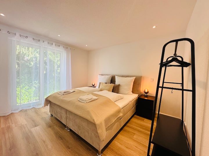 ห้องนอนพร้อมเตียงบ็อกซ์สปริงและราวแขวนเสื้อผ้า