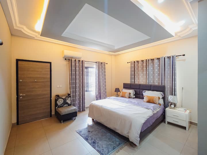 Furnished with a comfortable queen-sized bed, soft pillows, a wardrobe for storage, and a bedside table with a chair. Guests can also enjoy a television for entertainment, making it a cozy and relaxing space to unwind