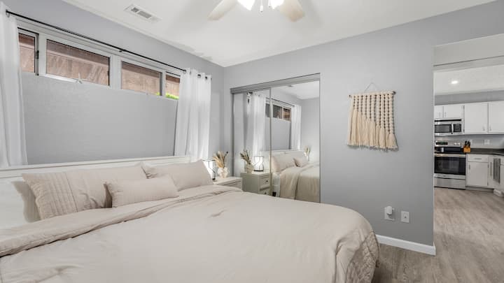 חדר האורחים המרוהט כולל שידות לילה, מנורות מגע, שידה, מיטת קינג סייז, ארון, טלוויזיה חכמה עם מסך שטוח גדול.