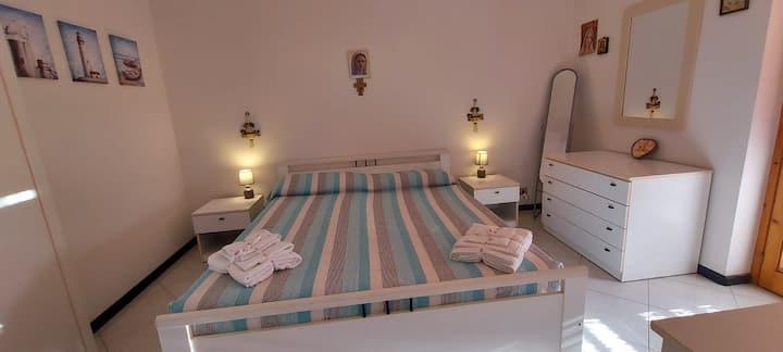 Glavna spavaća soba s udobnim bračnim krevetom i izravnim pristupom privatnom balkonu na stražnjoj strani (pogled na dvorište), uključujući tendu koja stvara hladan prostor za opuštanje. 