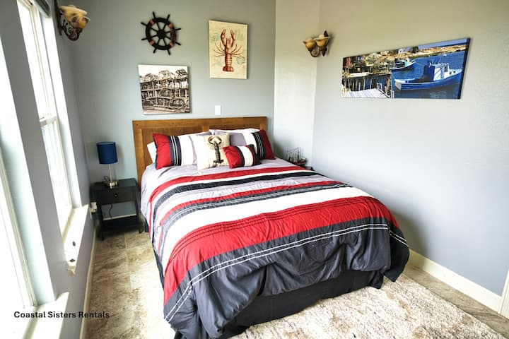 Slaapkamer met queensize bed en speelse kreeftendecoratie