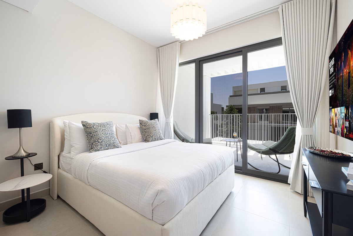 Просторна спалня с 65-инчов смарт телевизор – отваря се към балкона с двойни люлки за отдих.