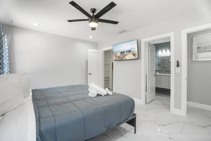 King bed with walk-in closet, Smart TV, and private bathroom. 