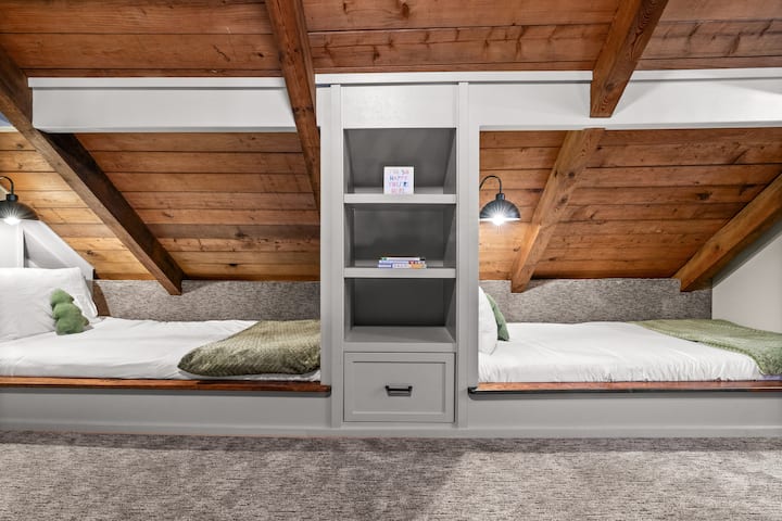 Loft avec deux lits jumeaux et un coin lecture confortable, parfait pour les voyageurs aventureux qui aiment grimper à l'échelle.