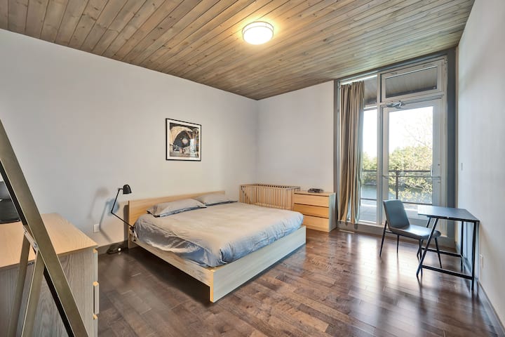 Chambre principale avec lit king size, lit bébé et accès à la terrasse